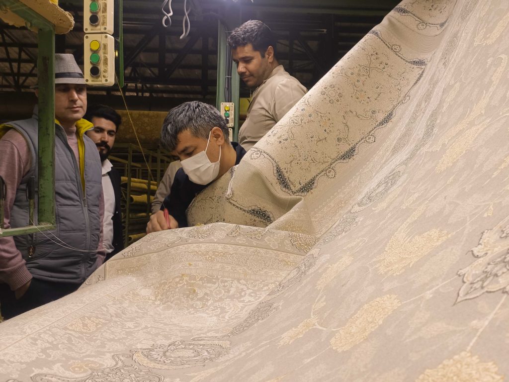 نیروهای کارخانه فرش مشهد در حال رفع ایرادات فرش